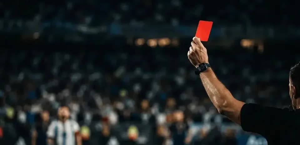 Referee showing red card to player during match