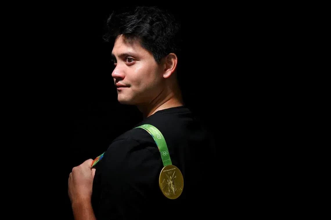 Athlete displaying Olympic gold medal on shoulder
