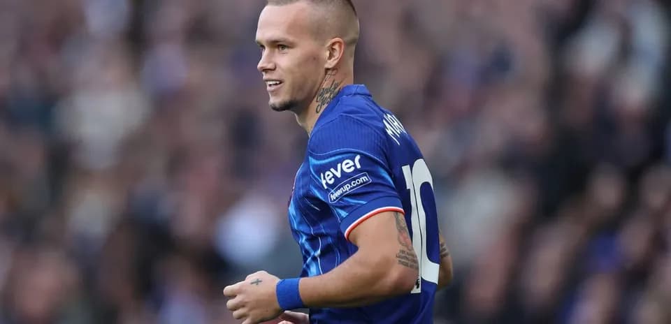 Futbolchi maydonda harakatda, ko'k forma kiygan