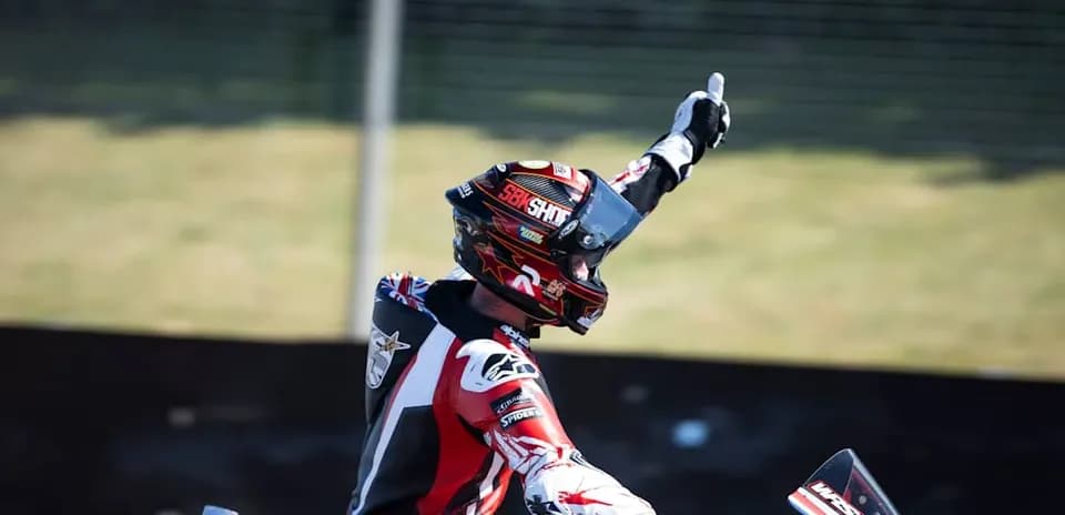 Motocross racer celebrating victory with raised hand