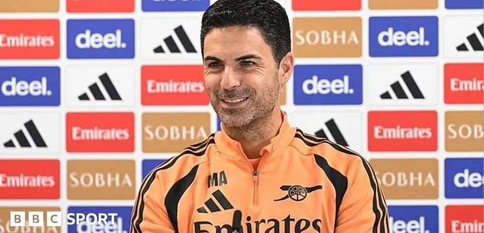 Mikel Arteta at press conference with sponsor backdrop