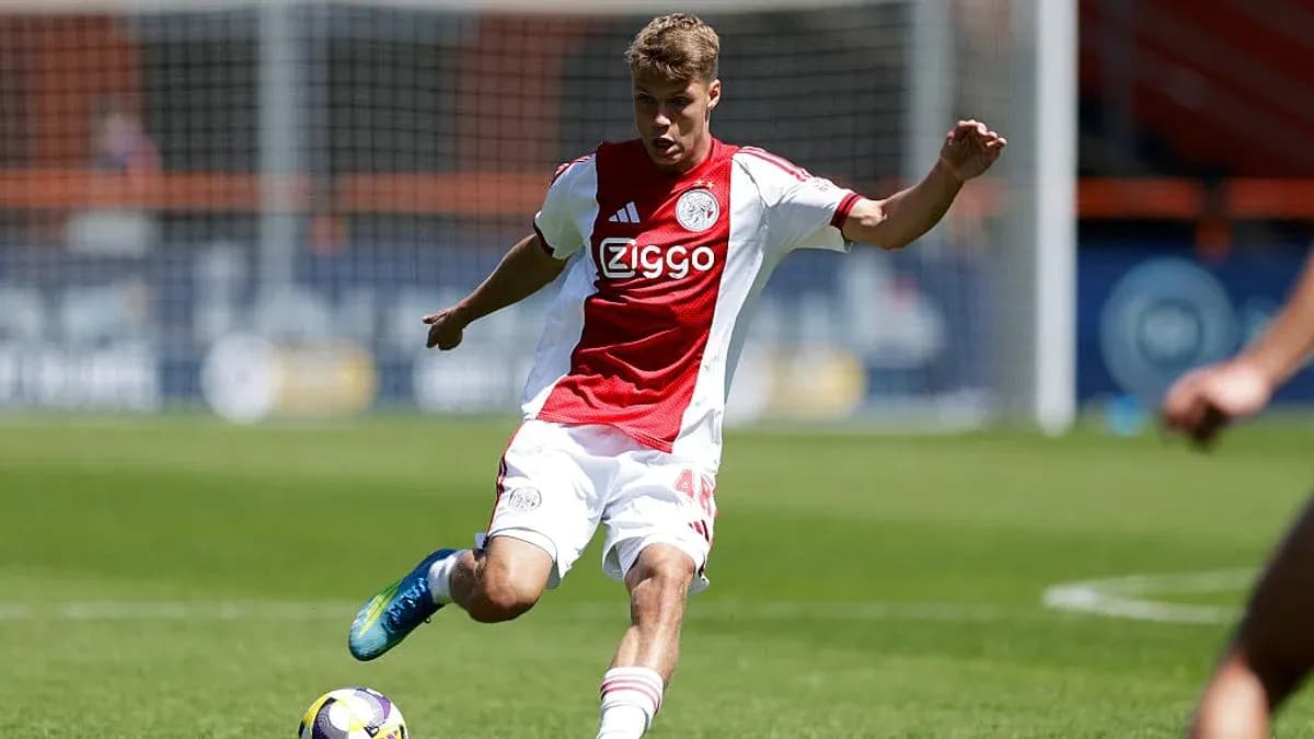 Futbolchi Ajax formasi bilan to'p tepmoqda