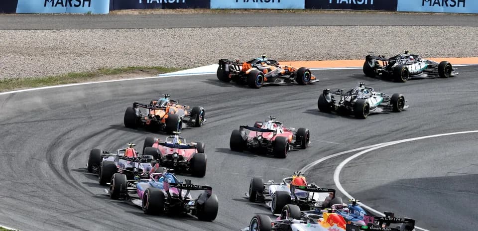 Formula 1 cars racing around a track corner