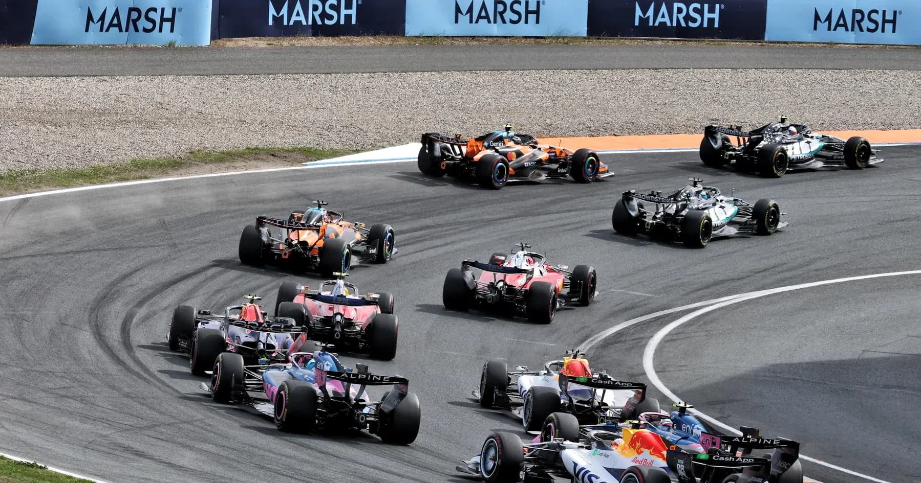 Formula 1 cars racing around a track corner