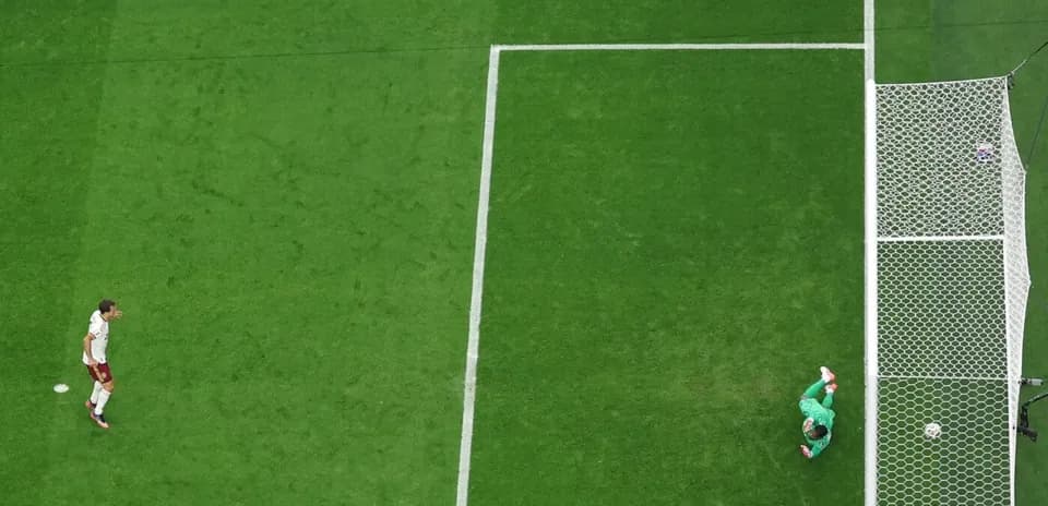 Player approaching goal while goalkeeper prepares to defend