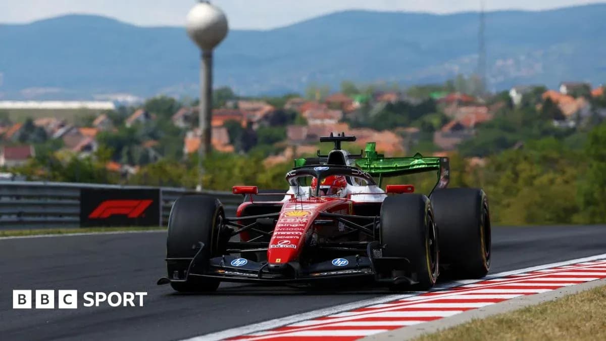 Formula 1 car racing on track with hills in background