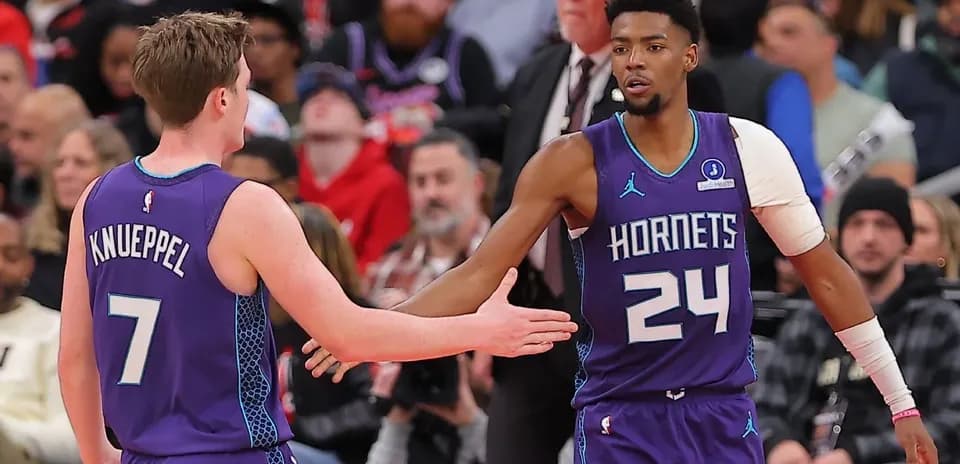 Hornets players exchanging a high five on court