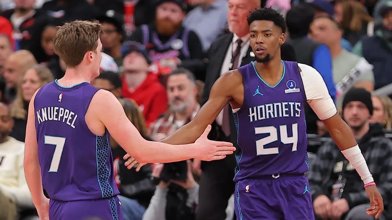 Hornets players exchanging a high five on court