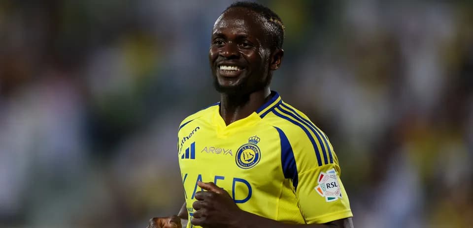 Futbolchi Al-Nassr formasida maydonda kulayotgan