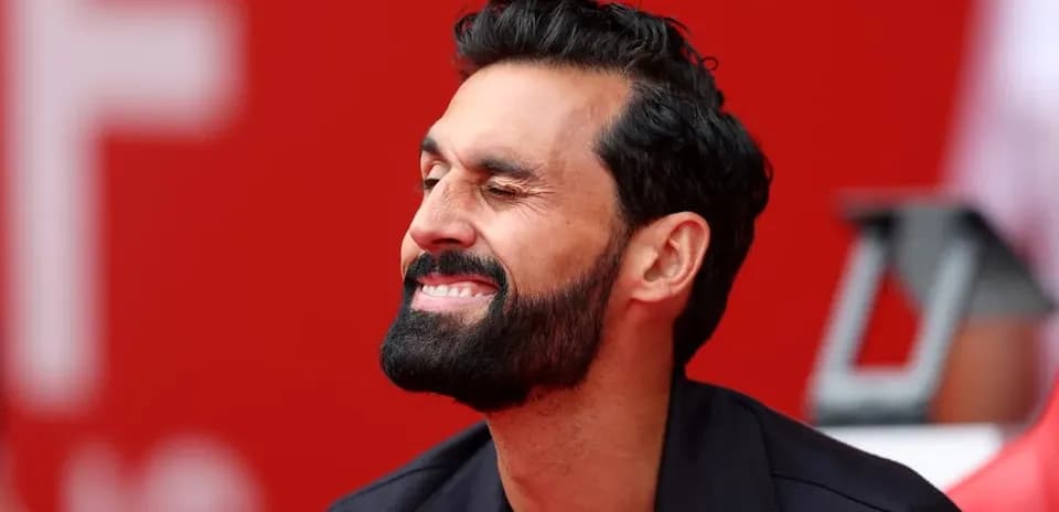 Man sitting with a smile against a red background