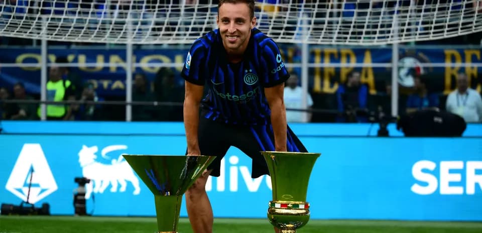 Futbolchi troflar bilan maydonda turibdi