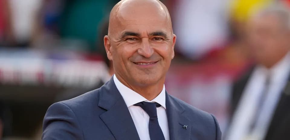 Bald man in suit smiling at event