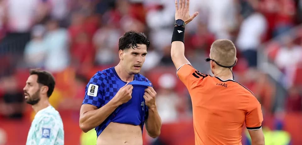 Referee showing card to player during match