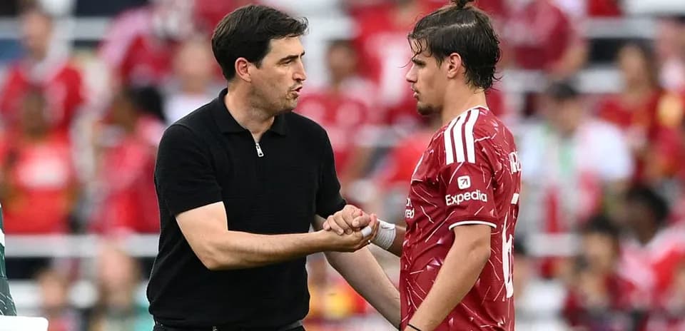 Trener futbolchi bilan o'yin davomida maslahatlashmoqda