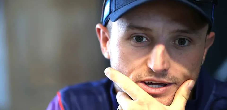 Man speaking with hand on chin during interview