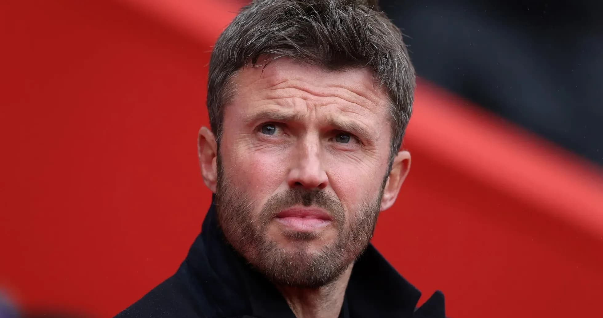 Men's football coach observing match from sidelines