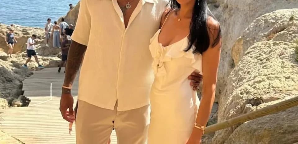Couple posing near rocky seaside during sunny day