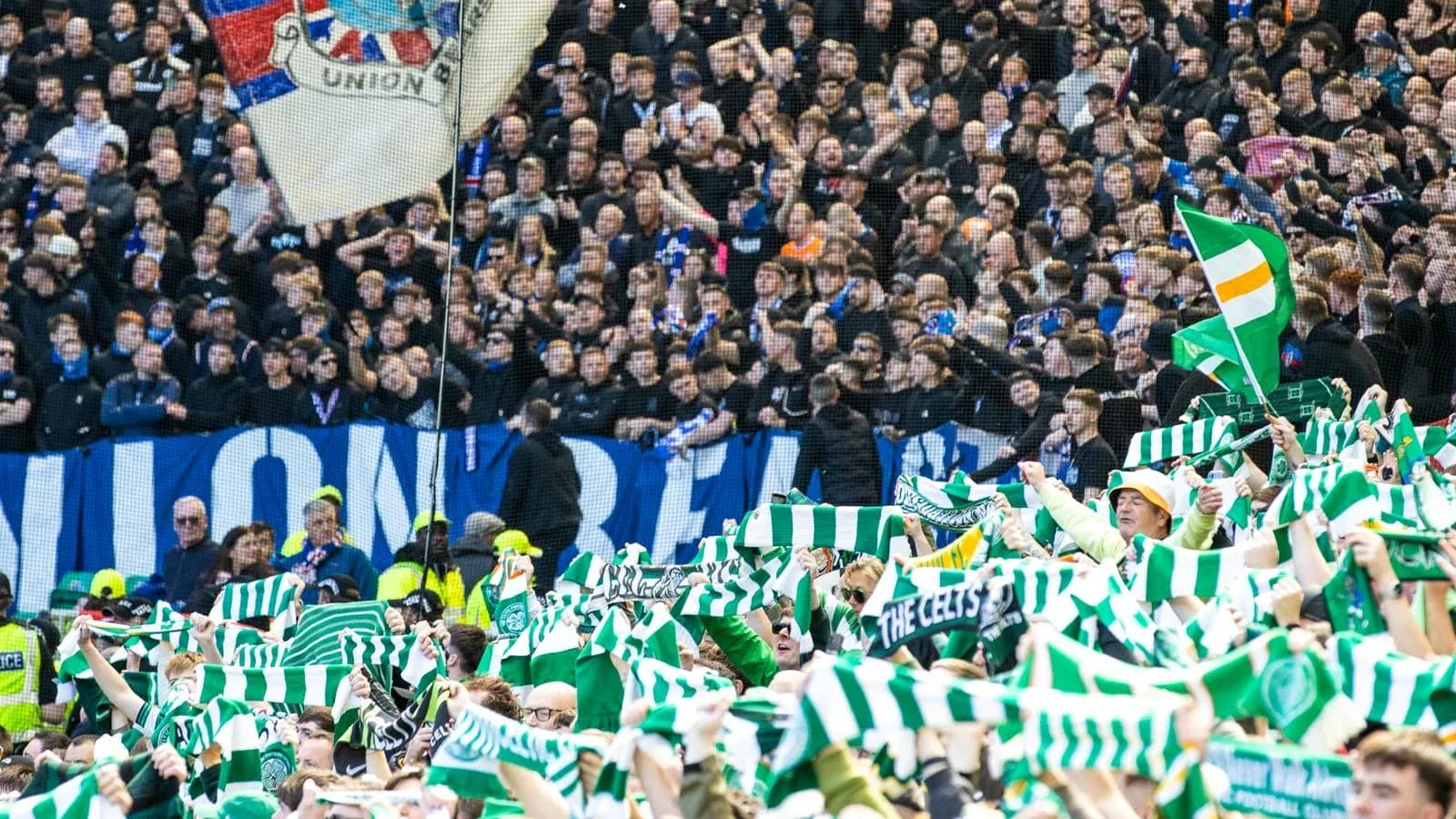 Celtic fans waving scarves in stadium crowd