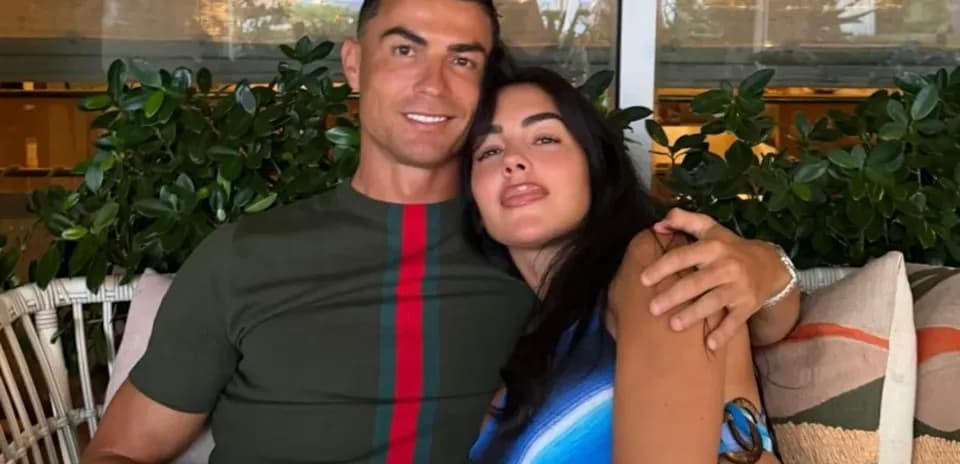 Couple posing together on a couch with plants