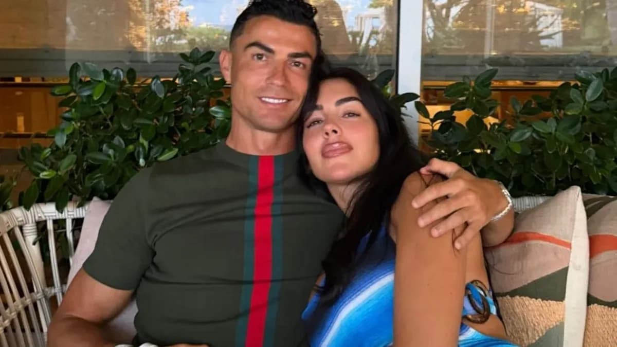 Couple posing together on a couch with plants
