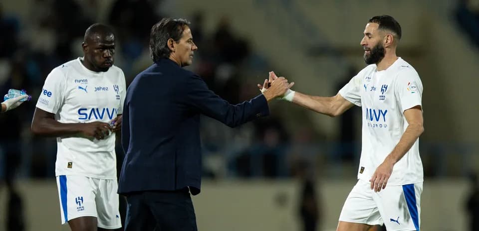 Trener futbolchilar bilan qo'l siqishmoqda