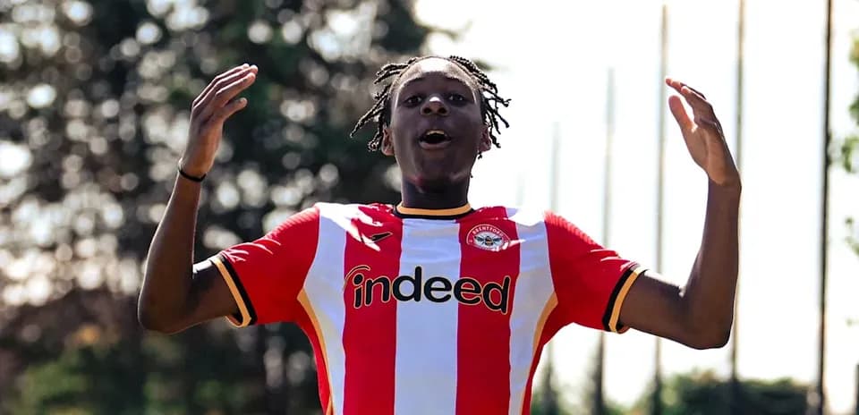 Futbolchi Brentford formasida qo'llarini ko'tarib turibdi