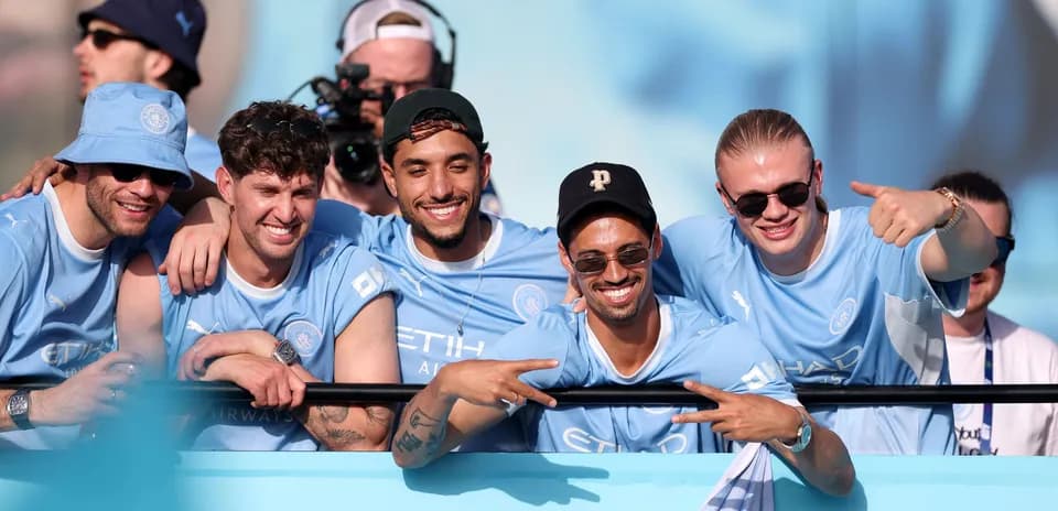 Five fans celebrating in Manchester City jerseys