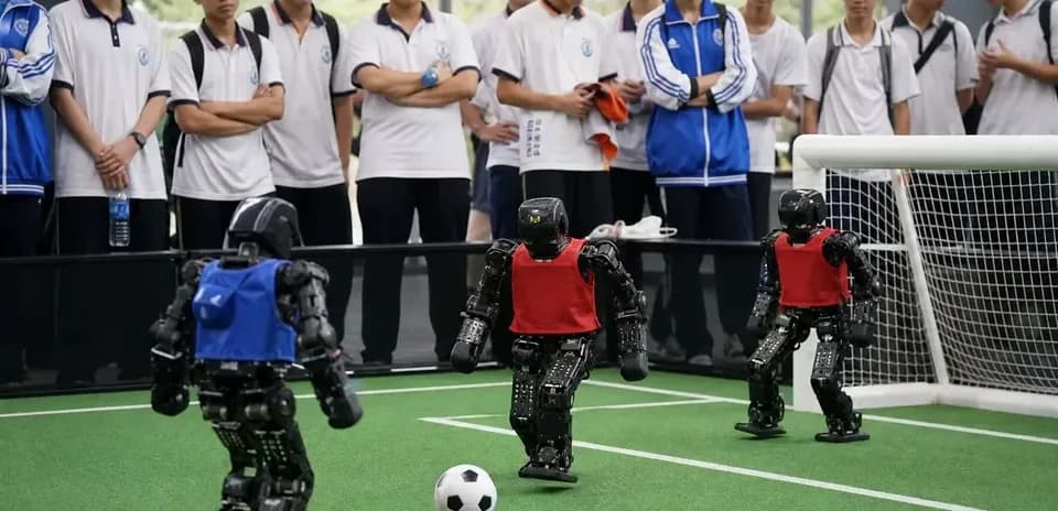 Robot soccer match with students watching