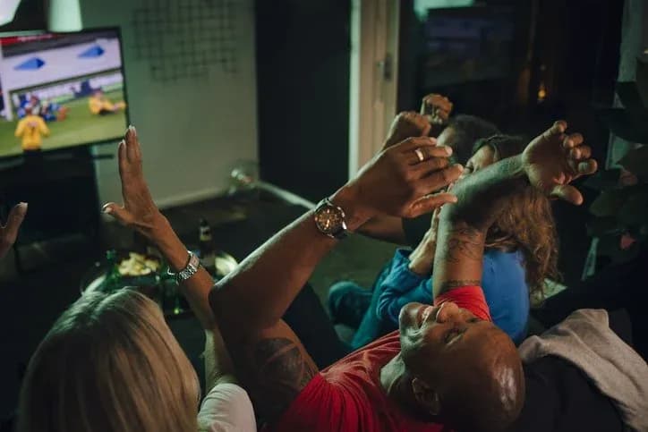 Group of friends celebrating while watching football match