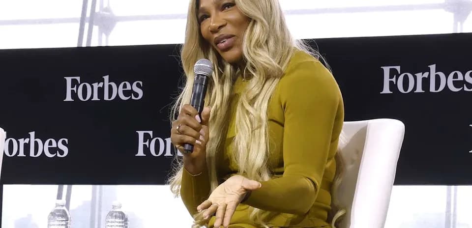Ayolda Forbes tadbirida mikrofon ushlab turibdi