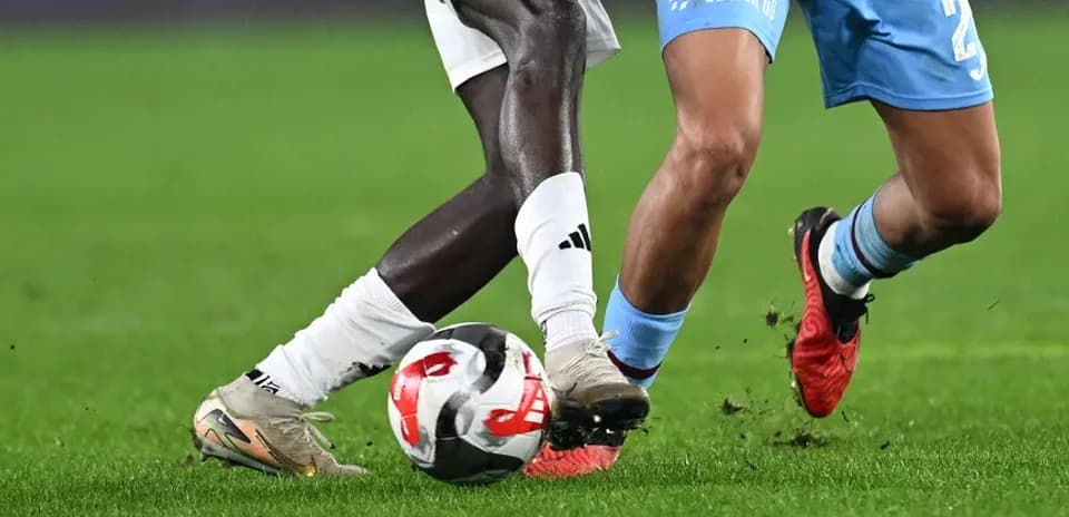Two players contesting for the ball on pitch