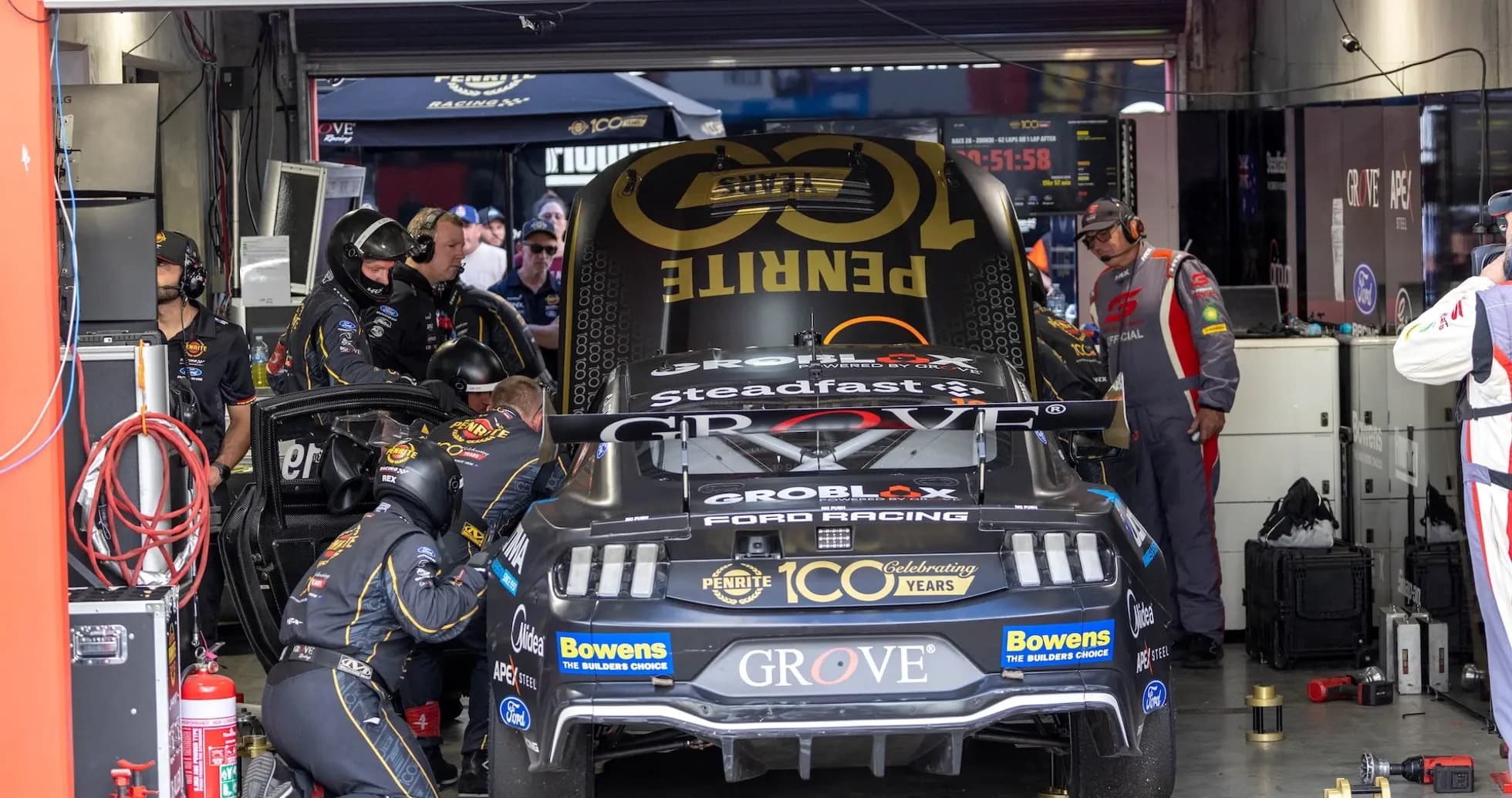 Pit crew working on car in garage area