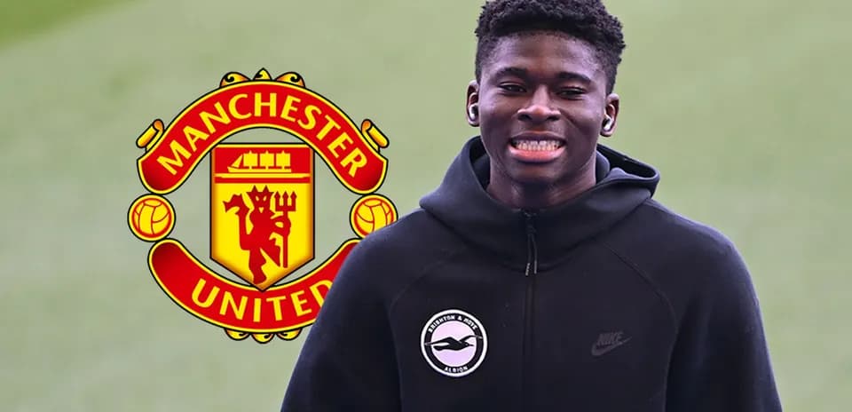 Yigit futbolchi Manchester United logosi oldida kulmoqda