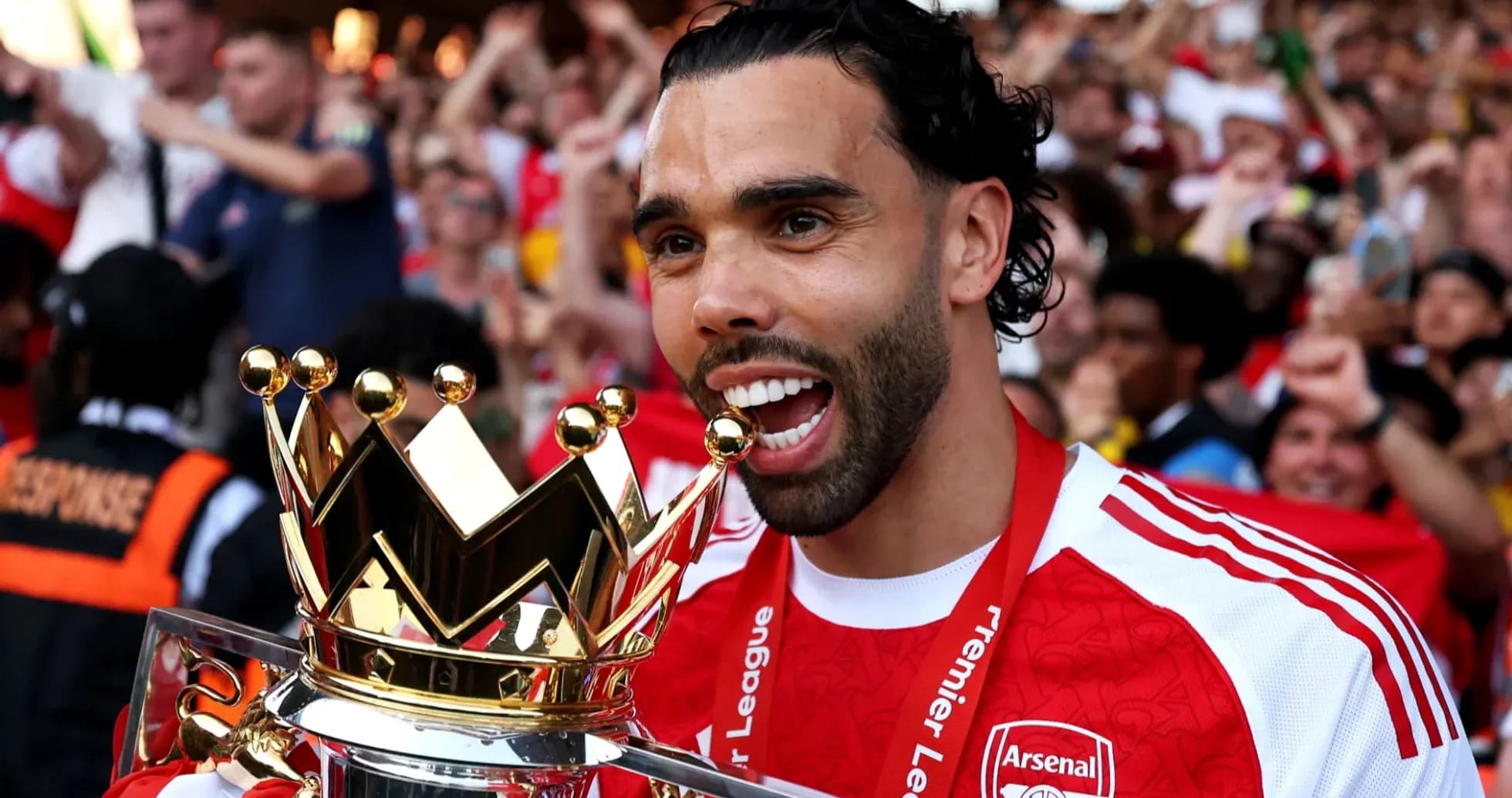 Futbolchi Premier League kubogini ushlayotgan