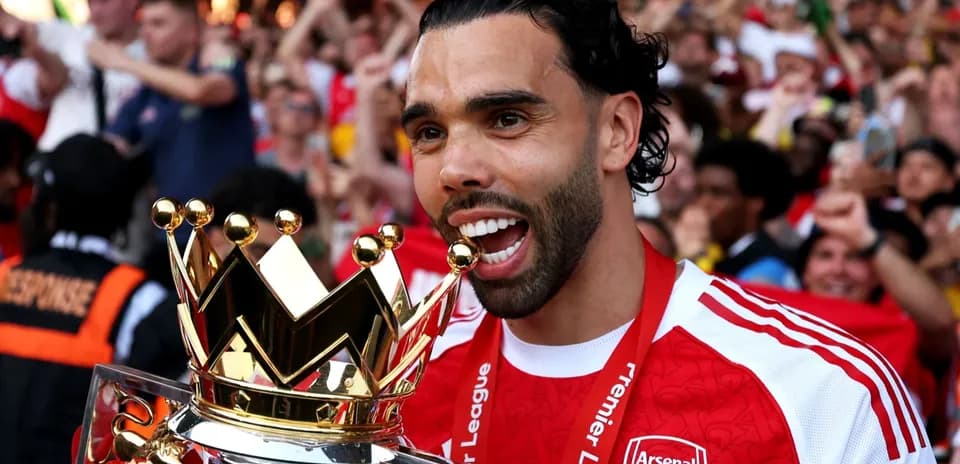 Futbolchi Premier League kubogini ushlayotgan