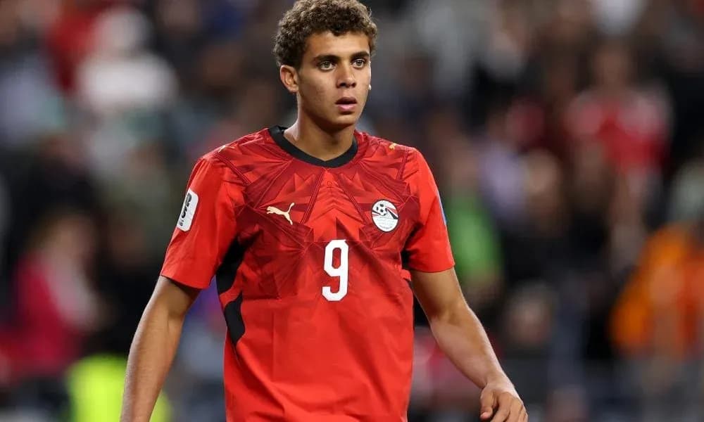 Futbolchi maydonda harakatda, qizil forma kiygan
