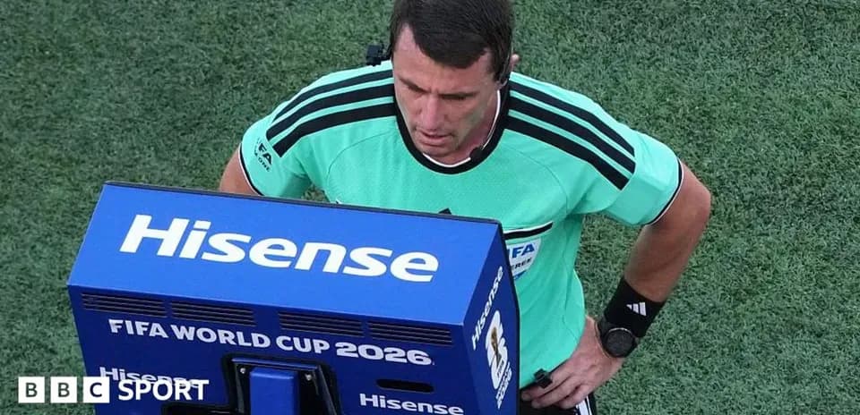 Referee reviewing decision on VAR monitor during match