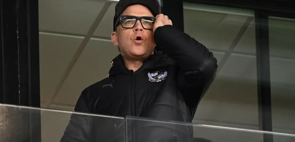 Person in a jacket shouting from a balcony
