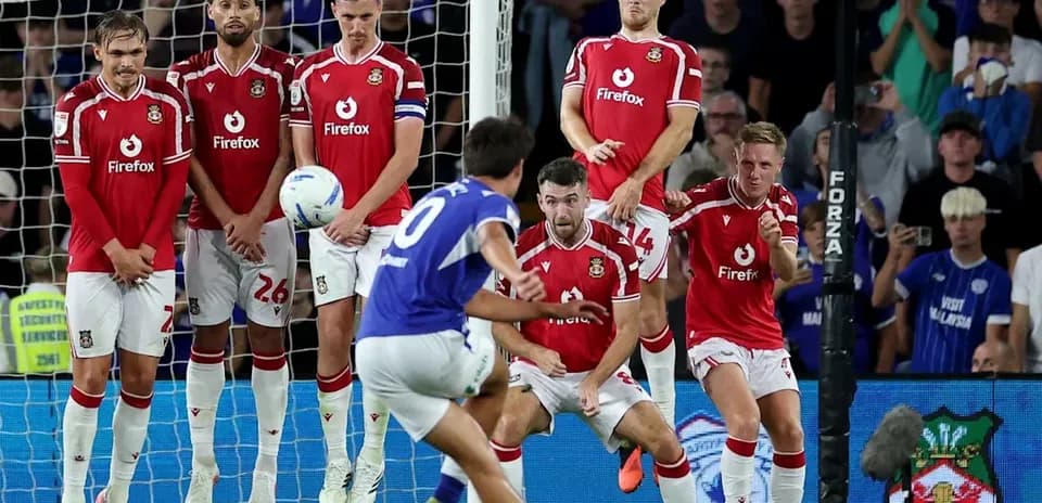 Player taking a free kick with wall defending