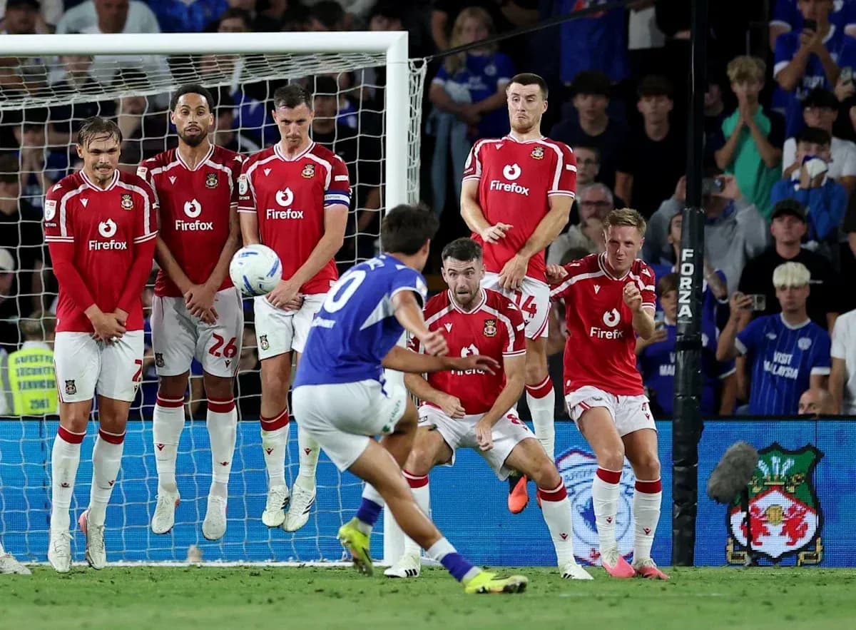 Player taking a free kick with wall defending
