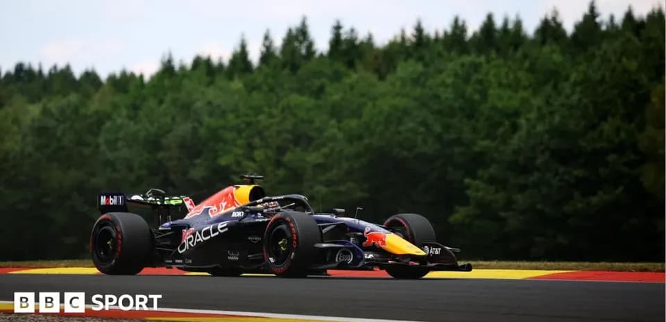Formula 1 car racing on track surrounded by trees