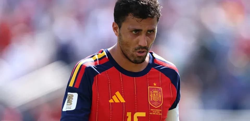 Futbolchi maydonda qizil va ko'k forma kiygan