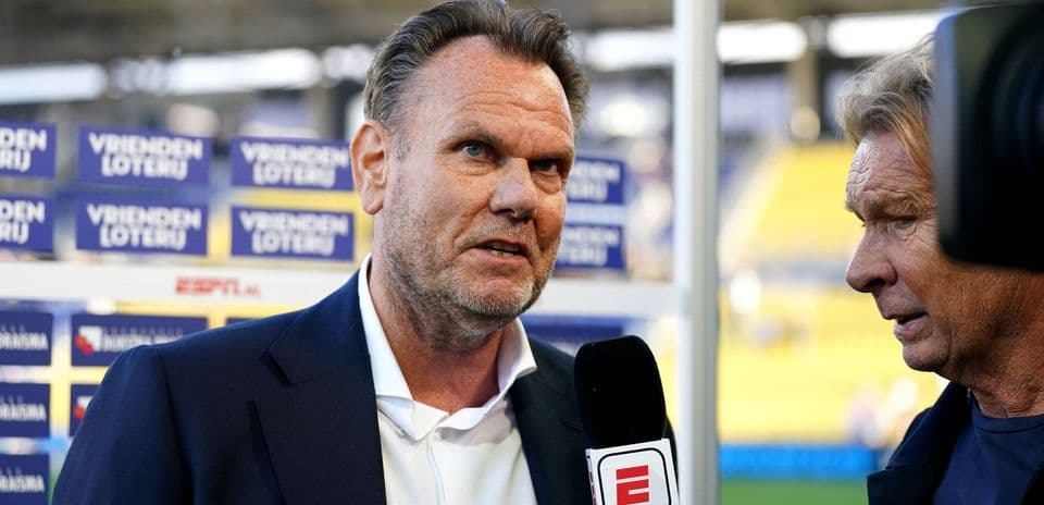 Interviewer speaking with a football manager on site
