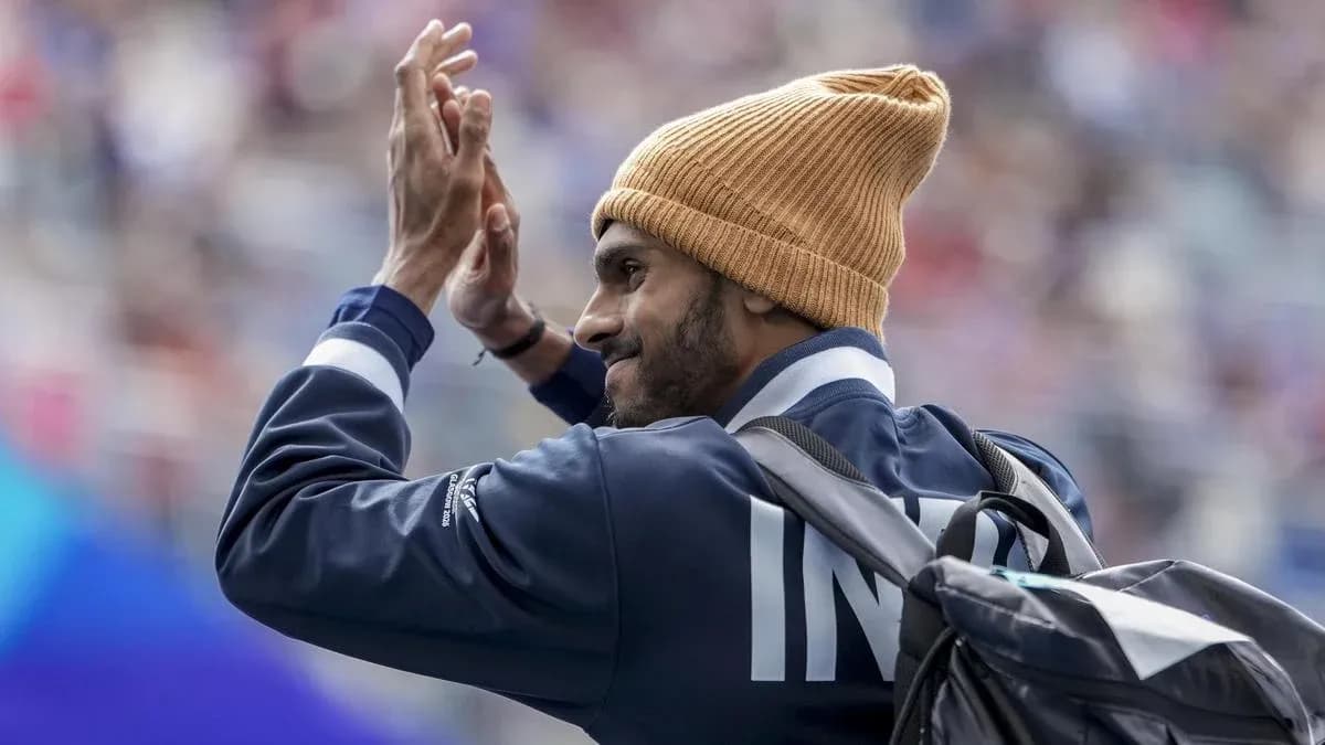 Athlete waving while wearing a beanie and jacket