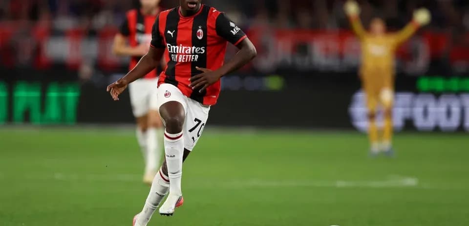 Futbolchi Milan formasi bilan to'pni olib ketmoqda