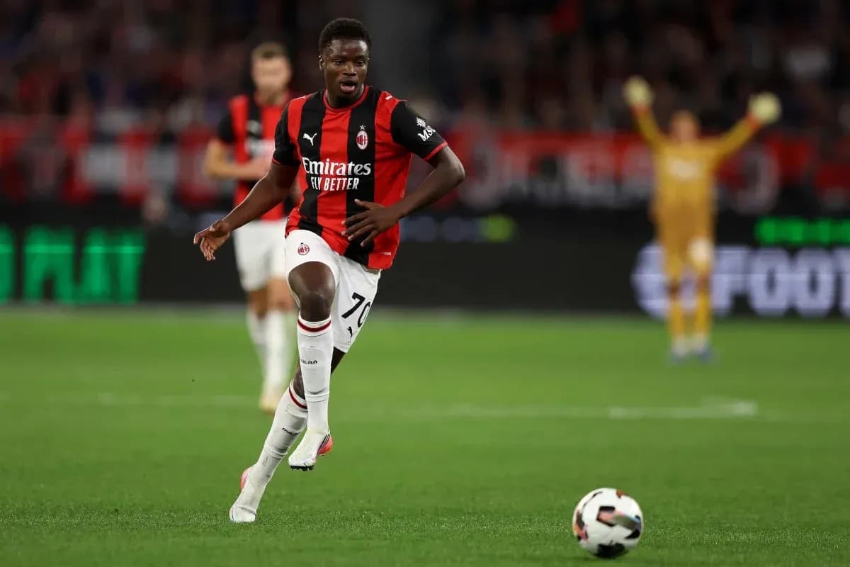 Futbolchi Milan formasi bilan to'pni olib ketmoqda