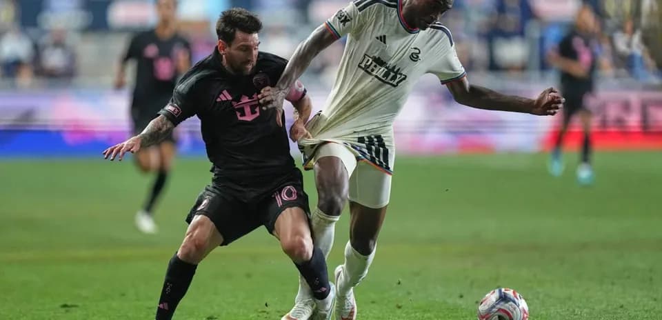 Messi and opponent battling for the ball during match