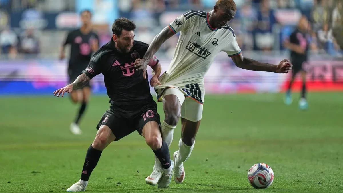 Messi and opponent battling for the ball during match