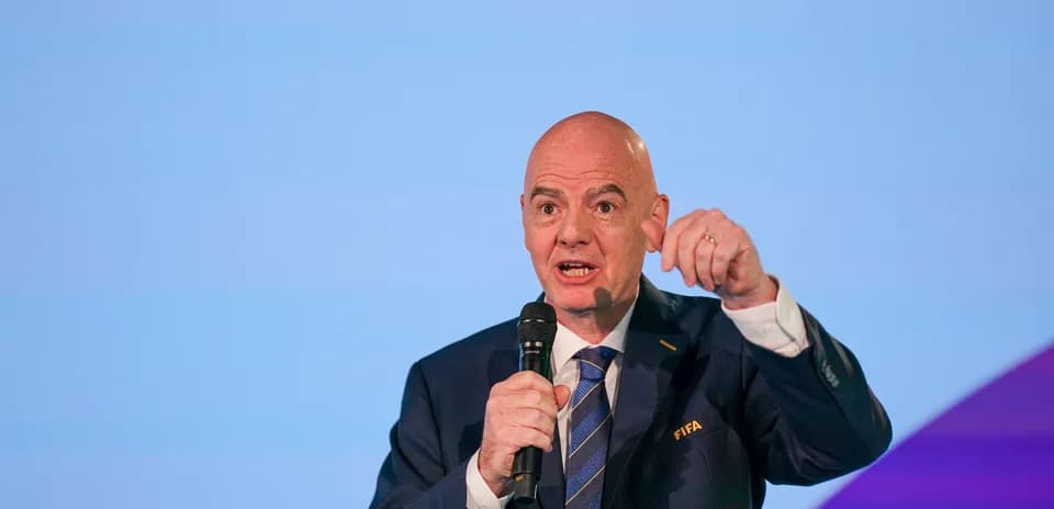 FIFA official speaking at a conference with microphone