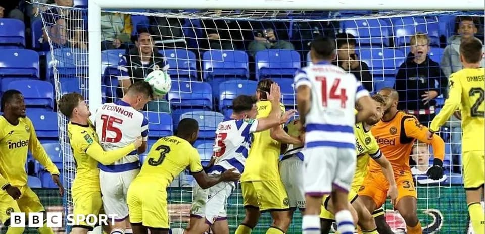 Players contesting a header in front of goal